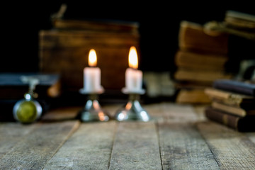 Old books and candles on a wooden table. Old room, reading room.