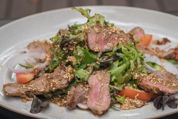 Close up Roasted beef with herbed bread crust sliced and vegetable. (selective focus)