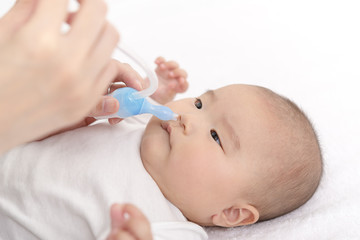 Obraz na płótnie Canvas 赤ちゃんの鼻水を吸引する
