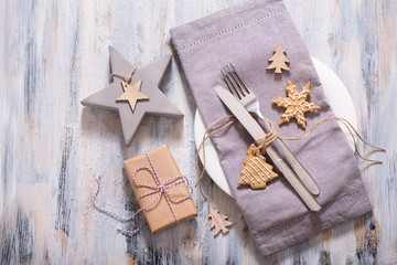 Fototapeta premium Christmas table setting with christmas star decoration, present box and gingerbread cookie copy space