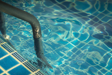 Grab bars ladder in the blue swimming pool