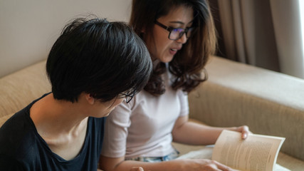 Two Asian woman friends reading books and discussion on hobby