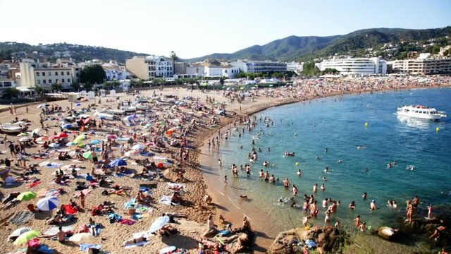 TOSSA DE MAR, SPAIN - AUGUST 17, 2017: View of crowded beach on hot sunny day
