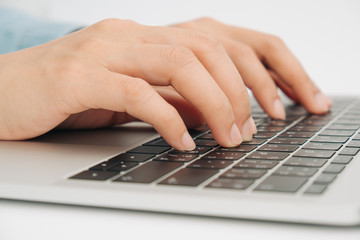 Female hands typing on keyboard of laptop, working at home concept, Closeup of business woman hand typing on laptop keyboard