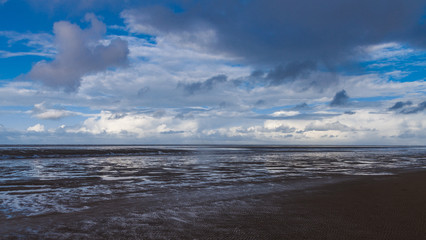 Obraz premium Wolkenformationen über dem Wattenmeer