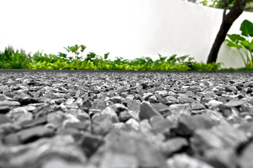 Fototapeta premium Backdrop of grey gravel stones with grass in outdoor space, low angle view.