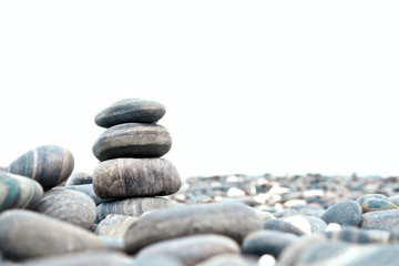 Stones stack isolated on white background. Seashore and beach. Close up.