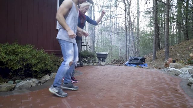 Looking through fire, a mature woman and her hip muscular teen son do a middle eastern line dance, the dabke.