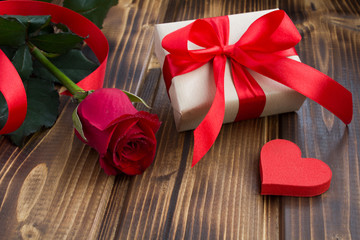 Gift box,red rose  and heart on the wooden background