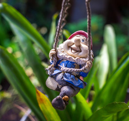 Garden gnome figurine swinging
