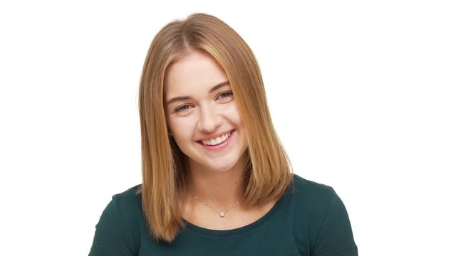 Portrait of amazing woman with caucasian appearance feeling good smiling with perfect teeth while standing over white background. Concept of emotions