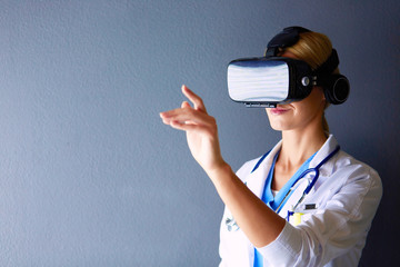 Female doctor wearing virtual reality glasses isolated on white background