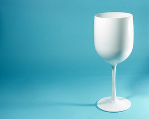A glass of white wine on a light blue background. 