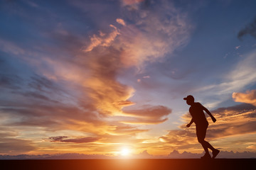 Silhouette of happy people running on street in sunset.