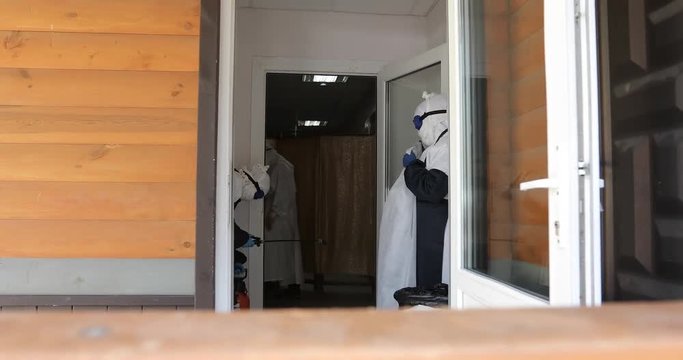 Doctor or nurse wearing full Ebola virus protection robe waiting for patient near the door.