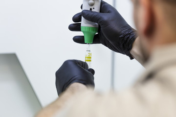 Men handling with liquid in a professional laboratory