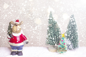 Miniature Christmas Santa cros and Tree on snow over blurred bokeh background,Decoration Image for Christmas Holiday and Happy New Year Gift box Celebration concept.
