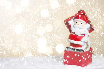 Miniature Christmas Santa cros and Tree on snow over blurred bokeh background,Decoration Image for Christmas Holiday and Happy New Year Gift box Celebration concept.