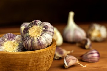 Garlic in a wooden bowl on a kitchen board. Superfood. Traditional folk medicine.