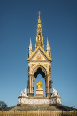 Fototapeta na wymiar The Albert Memorial is situated in Kensington Gardens, London, directly to the north of the Royal Albert Hall. It was commissioned by Queen Victoria in memory of her beloved husband, Prince Albert