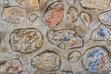 Multicolored stones in concrete. Background.