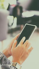Blurred focus of a woman using mobile smart phone in coffee shop, vintage color tone process for business technology background
