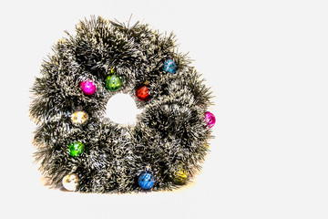 Christmas decoration in the form of a circle with multi-colored balls on a white background.