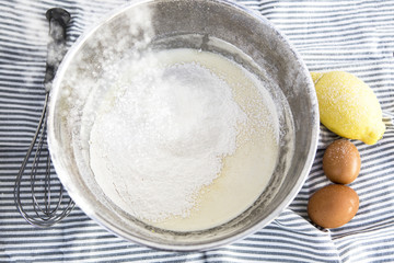cuenco de metal con una mezcla de leche y harina para hacer una masa para biscochos.