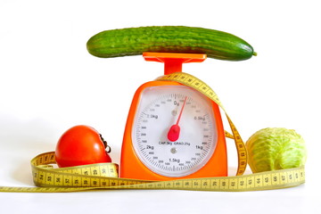 yellow measuring tape and thekitchen  scales, diet vegetables, cabbage, cucumber, tomatoes, isolated on white background