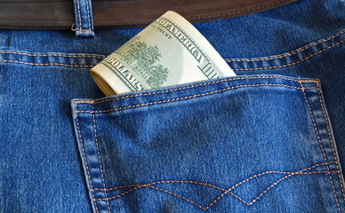 rolled money dollars sticking out of jeans pocket