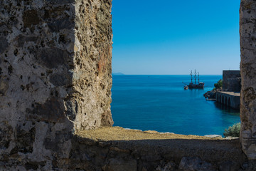 The fortress wall on the background of the sea and the ship.