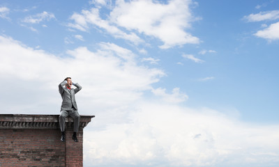 Young man on building roof dont want to hear anything
