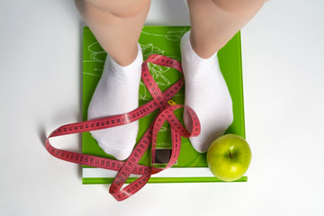 Girls feet on the scales close up.