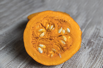 Cut in half pumpkin on a light wooden board