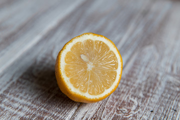 Half of a lemon with a bone on a light wooden board