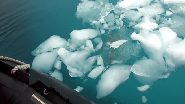 Ice floe and rubber boat in ocean of Antarctica. Glacier on background of snow mountains.Travel in calm and silence of cold polar north. Scenic blue water. Unique nature of desert . Wilderness area.