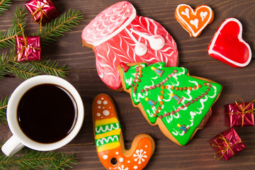 White Cup of hot coffee , gingerbread and christmas decor on brown wooden background .The view from the top