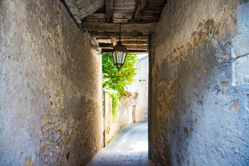 Fototapeta premium Passage in a narrow ancient street with wooden beams and a lantern.
