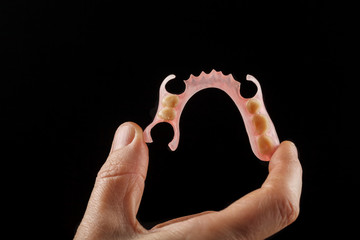 Dental prosthesis in the hand of the dentist.