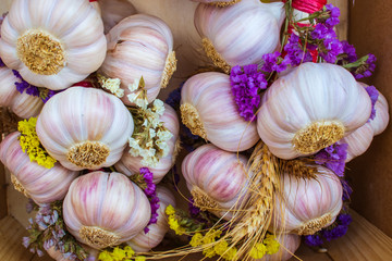 Bunches of garlic with little interwoven flowers.