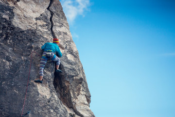 The girl climbs the rock.