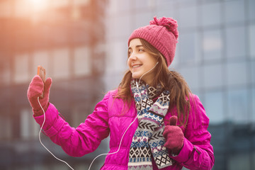 Woman in pink winter jacket listen music