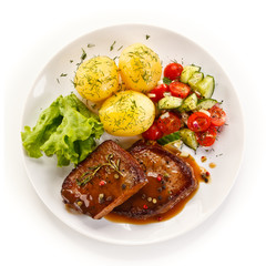 Grilled steak with vegetables on white background 
