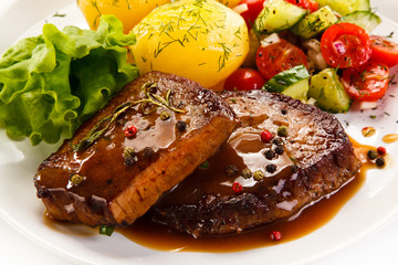 Grilled steak with vegetables on white background 