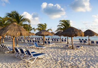Empty sunbeds on the shores of the Caribbean ocean. Early morning sun rising, no people on the...