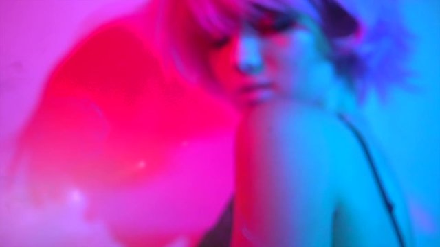 Disco girl dancing on party. Young model woman in colorful bright lights with trendy makeup and haircut. Slow motion 240 fps. 4K UHD video 3840x2160
