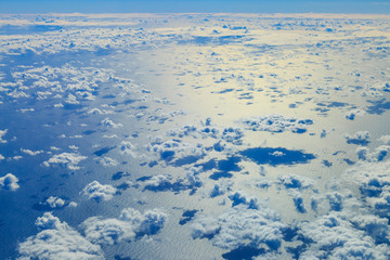 View from an Airplane of Clouds, and their Shadows on the Sea