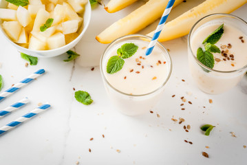 Summer fruits, refreshing drinks. Vegan food. Breakfast. Smoothie of yogurt, raw organic yellow melon, flax seeds and mint.