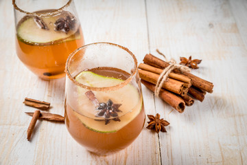 Autumn drinks. Mulled wine. Traditional autumn spicy cocktail with pear, cider and chocolate syrup, with cinnamon, anise, brown sugar. On a white wooden table. Copy space