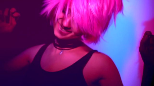Disco girl dancing on party. Young model woman in colorful bright lights with trendy makeup and haircut. Slow motion 240 fps. 4K UHD video 3840x2160